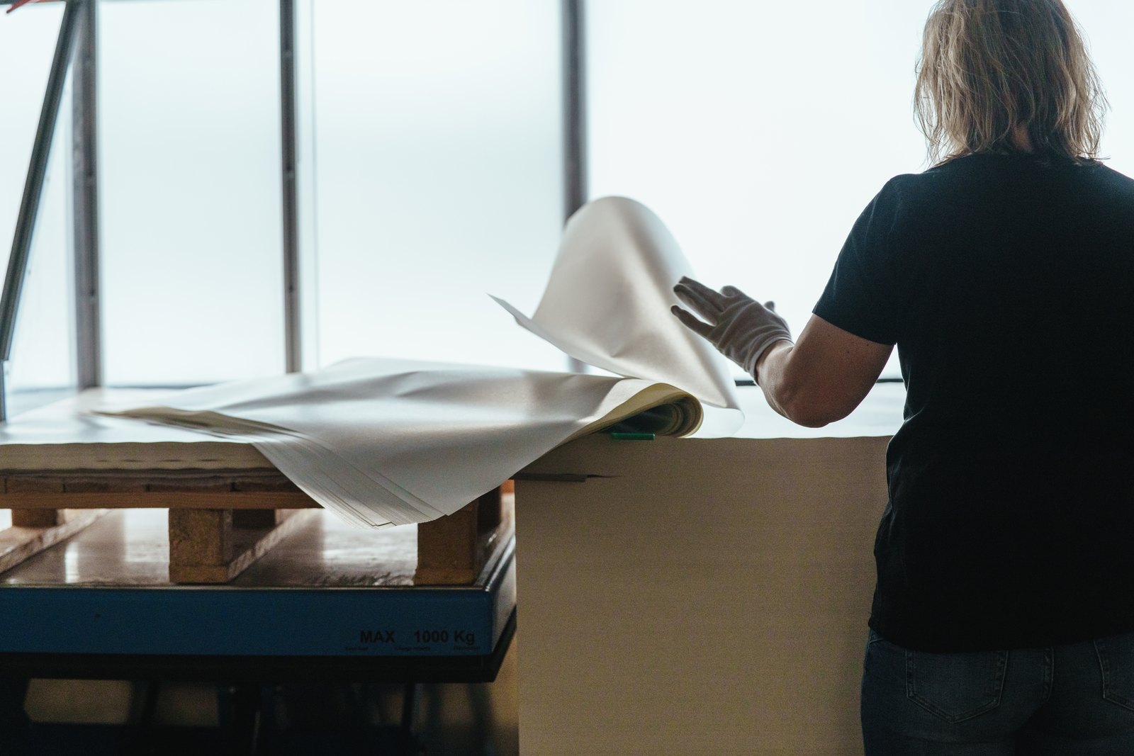A Lahnpaper employee turning a large sheet at the cutting machine in the mill